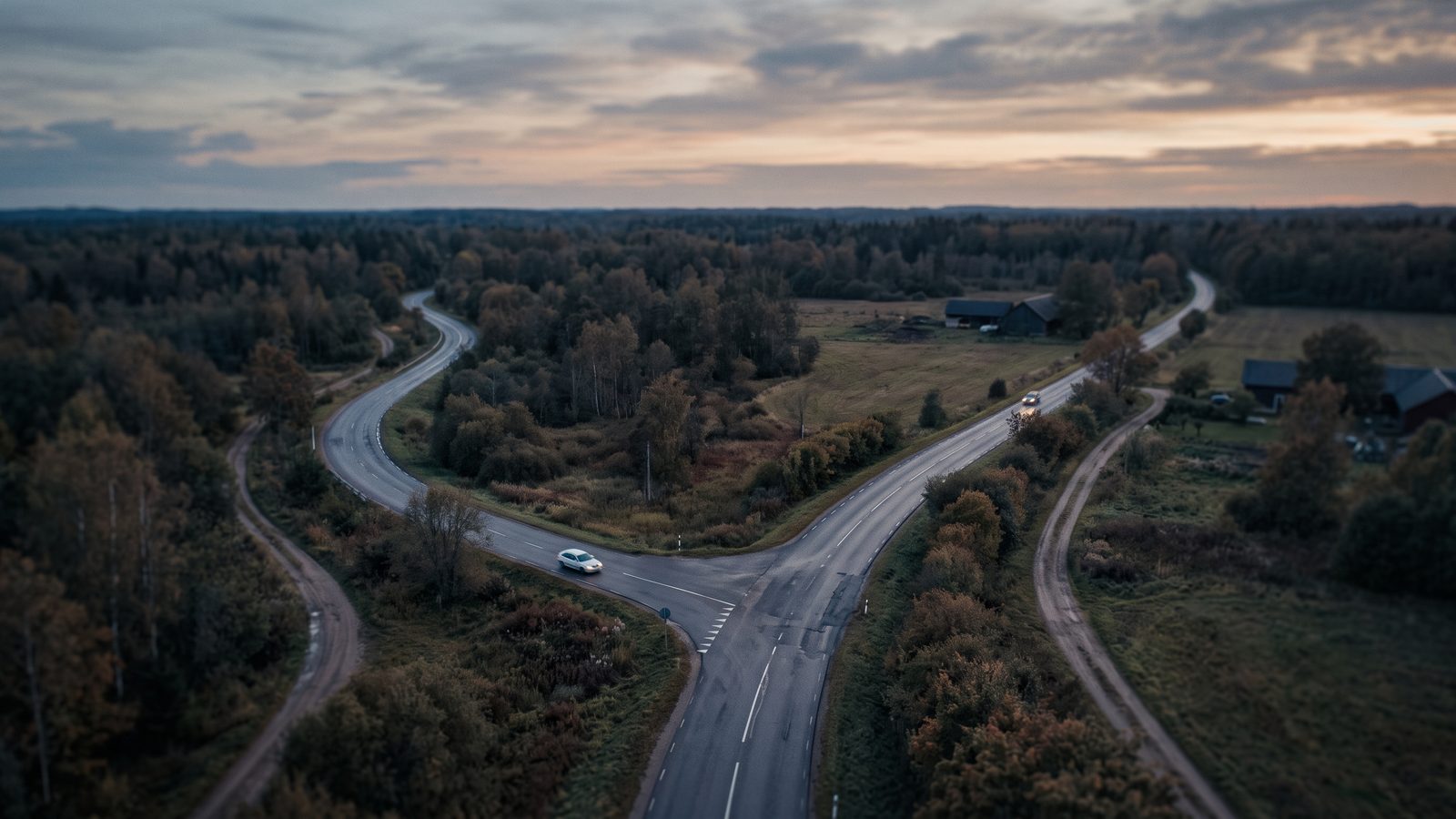 An aerial view of two roads diverging at dusk